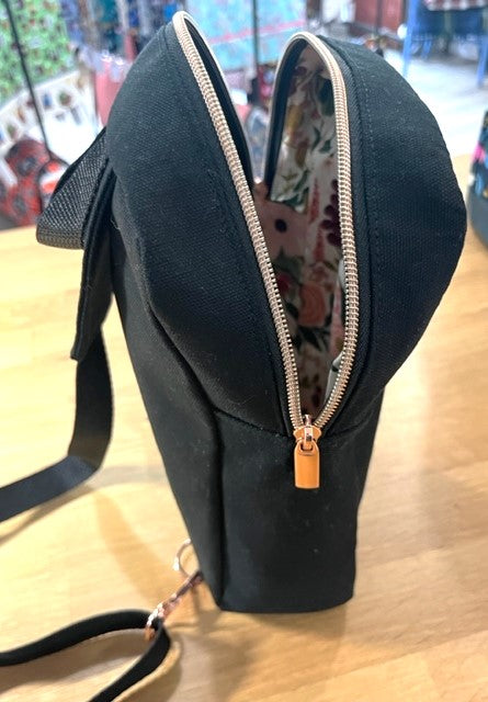 Black sling bag with open zipper