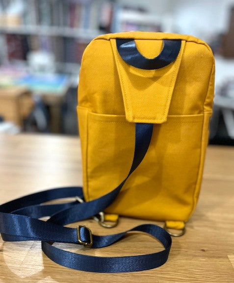 Mustard yellow sling bag with black strap back view
