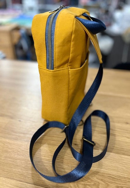 Mustard yellow sling bag with black strap side view