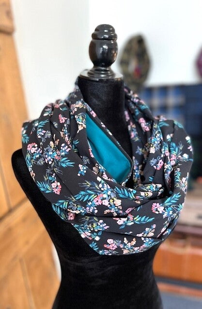 Hidden pocket infinity scarf with pink florals on a black background