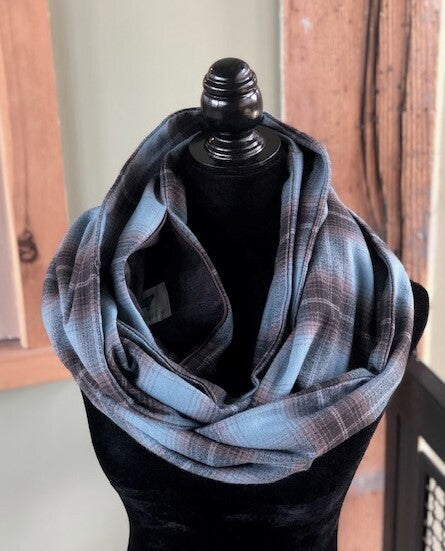 Hidden pocket infinity scarf with a light blue and brown plaid pattern