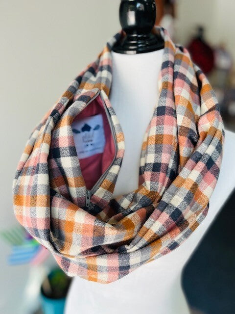 Hidden pocket infinity scarf with a pink, brown and dark grey plaid pattern