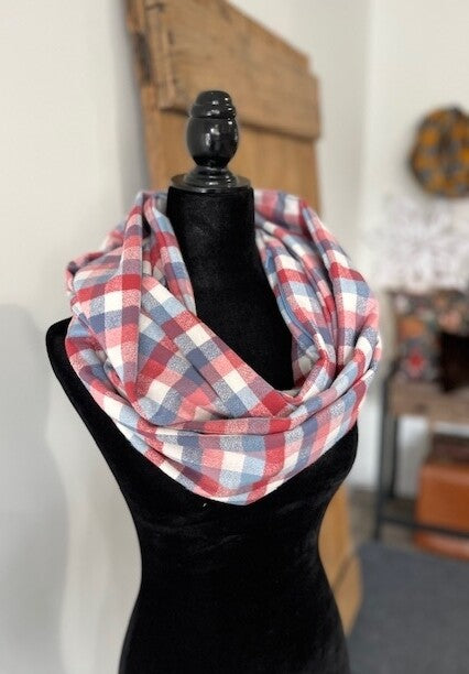 Hidden pocket infinity scarf with a red, blue and cream plaid pattern